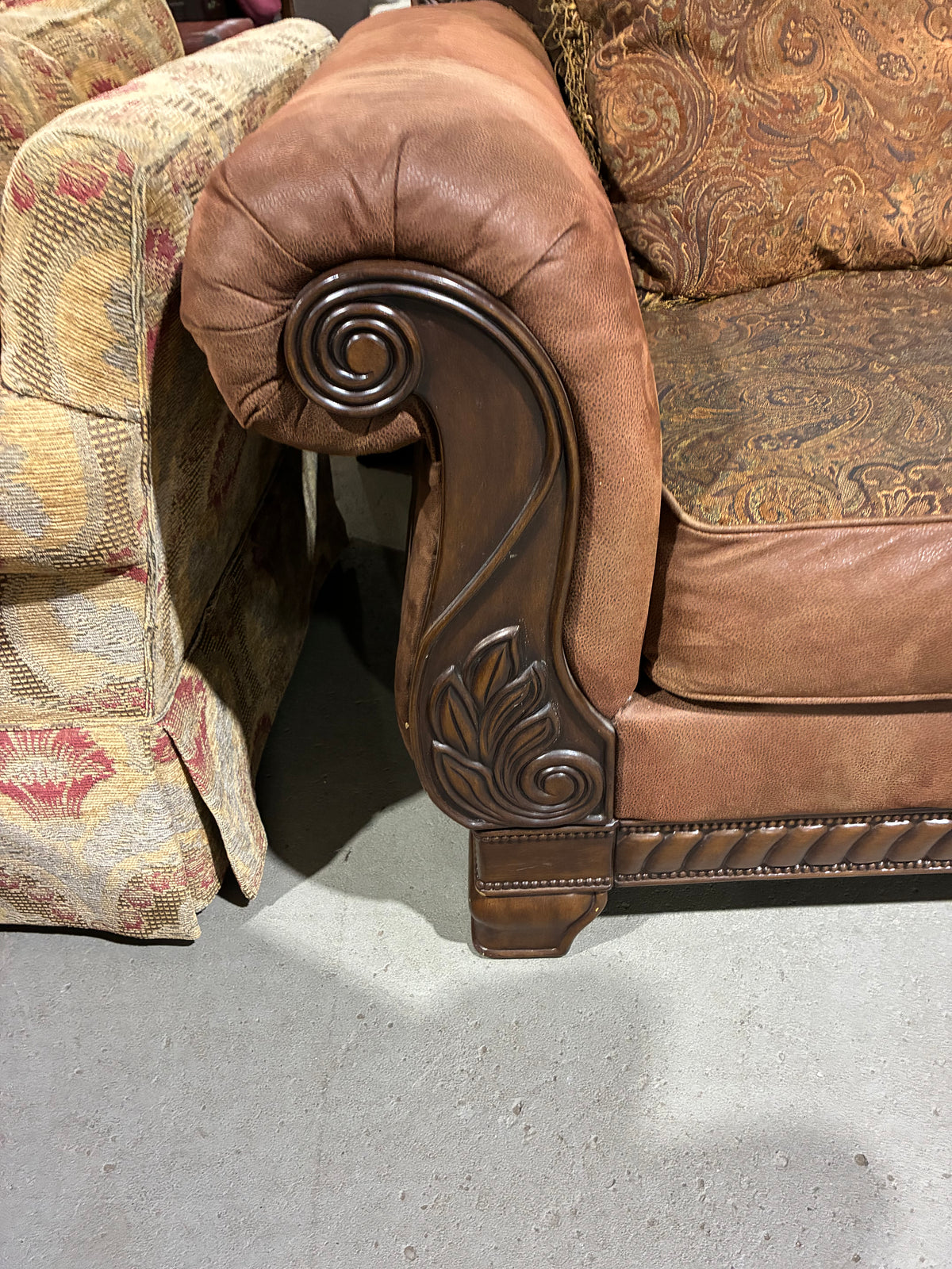 Traditional Brown Sofa with Ornate Carved Wood Accents & Paisley Cushions