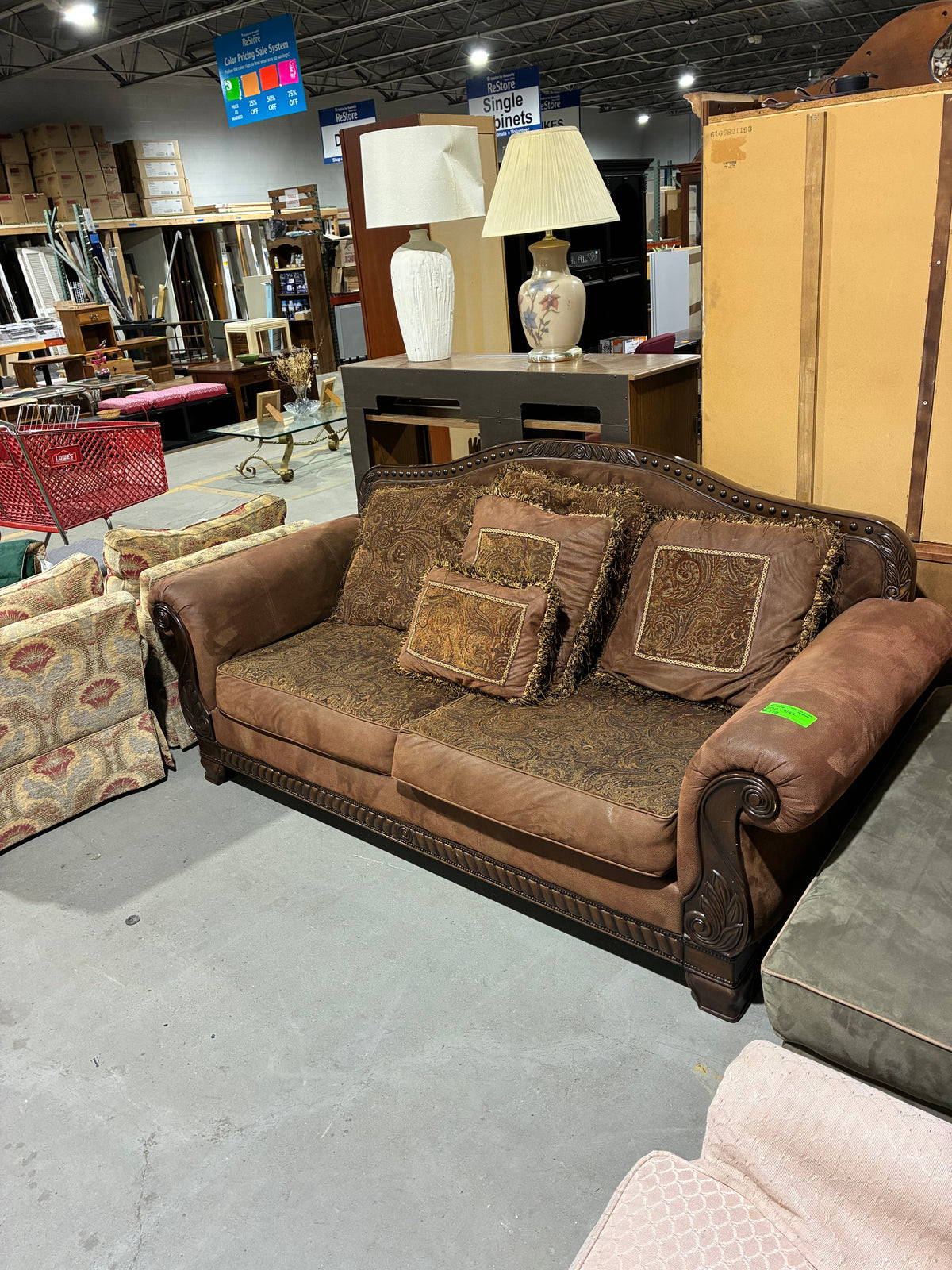Traditional Brown Sofa with Ornate Carved Wood Accents & Paisley Cushions